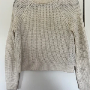 Beige stickad tröja från Vero Moda - Säljer en beige stickad tröja från Vero Moda i storlek S. Tröjan har en grovstickad struktur, rund halsringning och långa ärmar. Perfekt för lager-på-lager och chill dagar. Enkel och stilren design som funkar till det mesta.