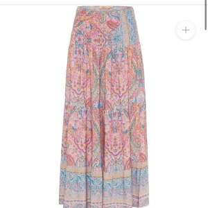Söt långkjol - Superfin långkjol med bohemiskt blommigt mönster i rosa, blått och gult. Kjolen har volangdetaljer och är tillverkad i luftig bomull, perfekt för varma dagar. Snygg att styla med en enkel topp och sandaler.