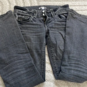 Grå jeans från Gina Tricot, stl 158 - Säljer ett par grå jeans från Gina Tricot i storlek 158. Jeansen har klassisk femficksdesign, bootcut och dubbla knappar i midjan. Perfekta till en avslappnad och cool look. De har ett jätte litet hål i sömmen på rumpan men inget man tänker på. 