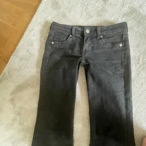 Svarta bootcut jeans - Snygga svarta jeans med bootcut passform och klassisk femficksdesign. Jeansen har normal midja och är tillverkade i ett mjukt denimtyg som ger en skön känsla. Perfekta för dig som gillar en tidlös och stilren look.