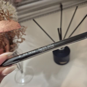 Fine Line Liquid Eyeliner svart - Snygg svart flytande eyeliner från Fine Line med tunn borste för precisa linjer. Vattenfast formula som håller hela dagen. Perfekt för att skapa skarpa vingar eller en klassisk cat eye-look.