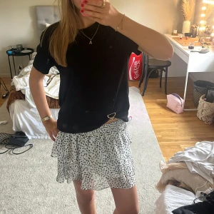 Volang kjol med prickar - Supersöt vit kortkjol med svarta prickar och volanger! Den är perfekt till sommaren och är från Chelsea!!💞💞Priset går absolut att diskutera💐🥰🥰