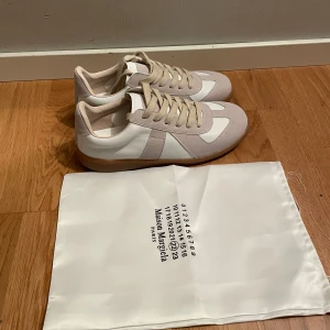 Maison Margiela  sneakers vit/beige - Ett par fina skor från Maison Margiela, köpte från en säljare i Plick men de är för små.  St 42,5. Pris kan diskuteras vid snabb affär