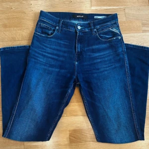 Mörkblå jeansbyxor från Replay. Pris kan diskuteras - Säljer ett par snygga mörkblå jeans från Replay med klassisk femficksdesign och diskreta slitningar. Byxorna har raka ben och normal passform, perfekt för en stilren vardagslook. Märkeslogga på bakfickan och knappgylf.
