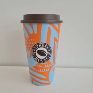 Espresso House Återanvändbar Kaffekopp Limited Edition - Säljer en superfin återanvändbar kaffekopp från Espresso House. Den här koppen är både snygg och miljövänlig.  Höjd med lock ca 15,5 cm.  *   Material: Tillverkad i tålig hårdplast. *   Skick: Använd endast ett fåtal gånger, i mycket gott skick. *   Design: Limited edition design i blått och orange. *   Märke: Espresso House, originalprodukt.  Perfekt att ta med till jobbet, skolan eller på utflykten. Köpt från Espresso House.