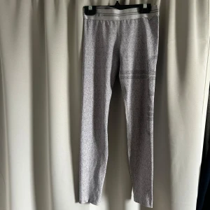 Grå leggings från Aim'n XS - Snygga gråmelerade leggings från Aim'n i storlek XS. De har bred resår i midjan med diskreta ränder och är tillverkade i stretchigt material som sitter tight och bekvämt. Perfekta för träning. Är lågmidjade 