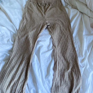 Beige ribbade byxor från SHEIN - Mysiga beige ribbade byxor från SHEIN i storlek S. Byxorna har en mjuk och stretchig känsla, med breda ben och hög midja. Perfekta för en avslappnad och trendig look.