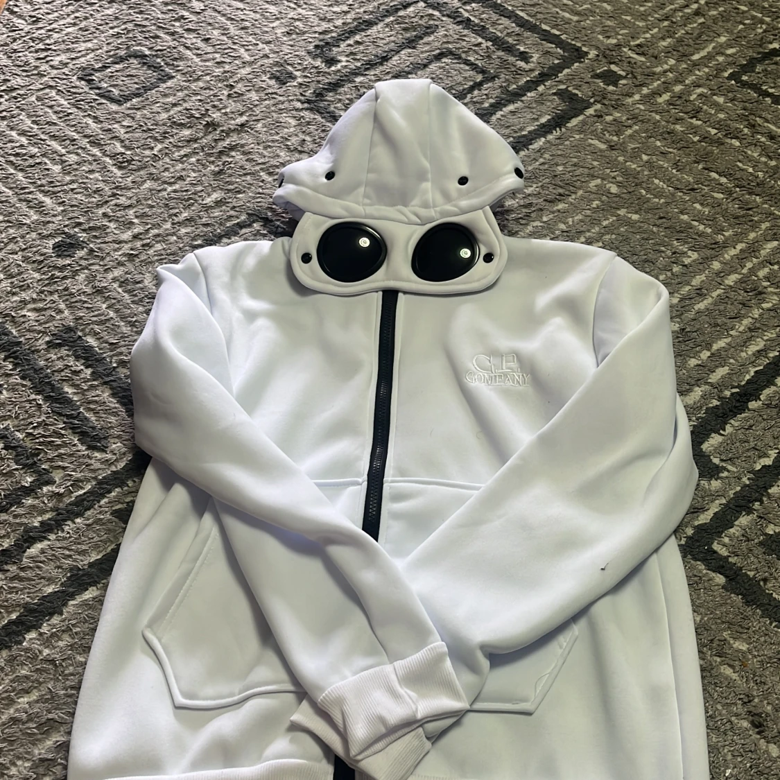 Vit hoodie med glasögon i huvan från C.P. Company