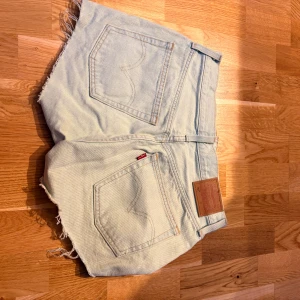 Ljusblå jeansshorts från Levi's - Ljusblå jeansshorts från Levi's. Midwaist och knapp-stängning