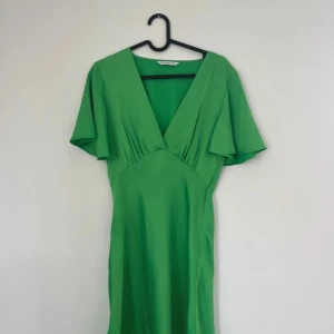 Grön omlottklänning från Stradivarius - Super söt grön kort klänning från Stradivarius. Perfekt för sommaren! Använd en gång. 