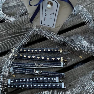 Jeansarmband - Unikt armband i ljusblått återvunnet jeansmaterial som även är handgjort och dekorerat med vita pärlor och guldfärgade metalldetaljer i rostfritt stål. Armbandet har en justerbar kedja för perfekt passform och själva jeansdelen är 10 cm lång. Kolla gärna in vår instagram: Jeanfluence.uf