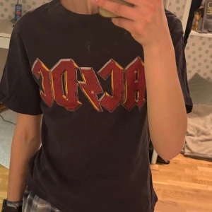  AC/DC t-shirt  - Cool svart t-shirt med stort AC/DC-tryck. Baksidan har även turnélistan tryckt i vitt. Klassisk passform och använd sparsamt