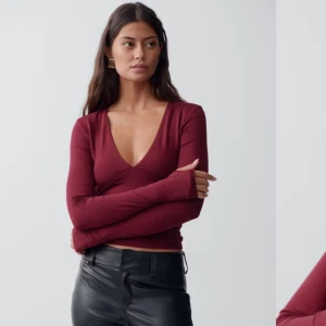 Vinröd långärmad topp med v-ringning - Vinröd långärmad topp med djup v-ringning och figurnära passform. Tröjan är i storlek XS, helt ny med prislappen kvar. Aldrig använd, så den är i perfekt skick. Enkel och stilren design utan synliga detaljer. Ny pris 299 men mitt pris går att diskutera.