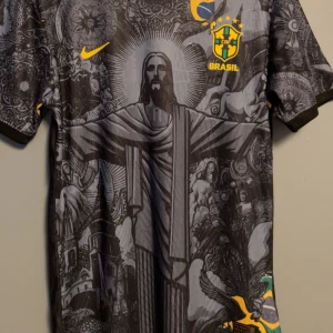 Brasilien fotbollströja  -  svart Brasilien fotbollströja från Nike med detaljerat grafiskt tryck av Kristusstatyn och brasilianska symboler. 
