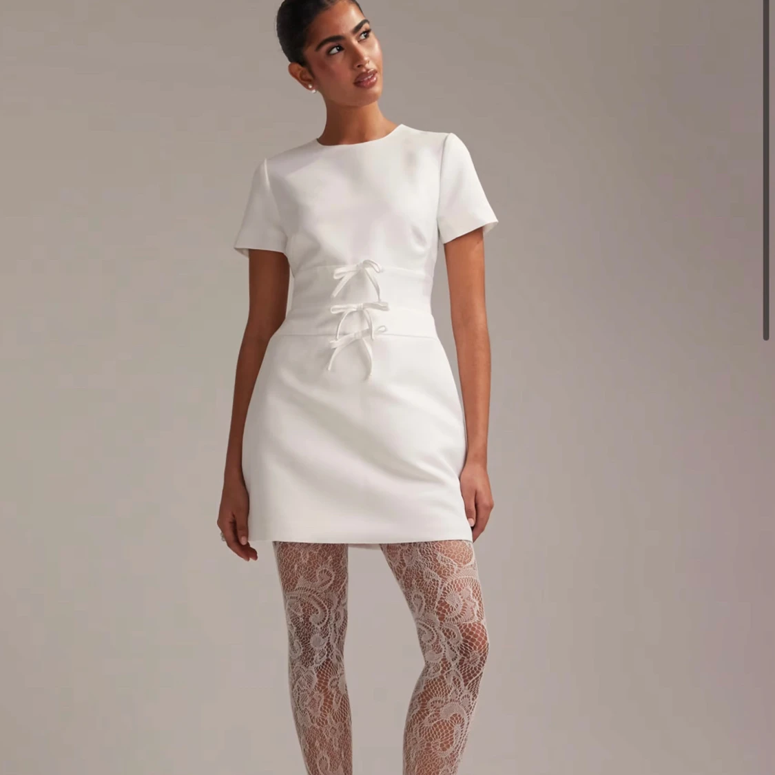 Vit kortklänning med rosetter och öppen rygg