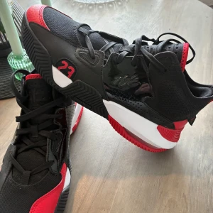 Svarta och röda Jordan sneakers - Säljer ett par snygga Jordan sneakers i svart och rött med vita detaljer. Skorna har nummer 23 på sidan och bak, samt klassisk Jumpman-logga. De har snörning och en platt sula, perfekt för dig som gillar streetstyle.