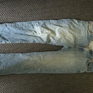 Blå jeans från Woodbird - Säljer ett par klassiska blå jeans från Woodbird i storlek 32/32. Jeansen har fem fickor, raka ben och normal passform. Perfekta för dig som gillar en tidlös stil med snygg tvättad denim.