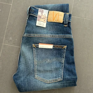 Nudie jeans - Nudie Jeans av modellen Thinn Finn Storlek: 32/36 - Skicket på jeansen är ny med prislapp - 100/10 - mitt pris: 599- Nypris: 1599kr.   En stor fördel med Nudies jeans jämfört mot Levis, Tiger of Sweden, Replay, Lee, Acne, dondup osv. Ar att du kan lämna in dem gratis for reparation eller uppläggning i Stockholm, Göteborg eller Malmö. Pa sa vis förlängs livslängden rejalt.
