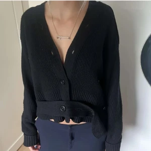 Svart ribbad kofta från H&M Studio - Säljer en snygg svart ribbad kofta från H&M Studio A/W 2020. Koftan har en v-ringning och knappar framtill, samt långa ärmar. 