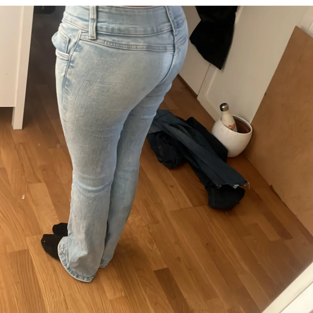 Snygga ljusblå jeans med bootcut-stil och låg midja. . Farkut & Housut.