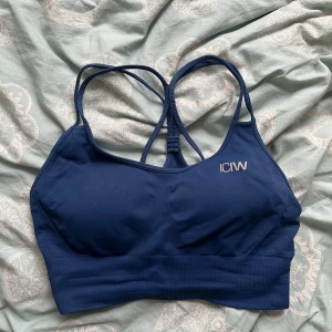 Mörkblå sporttopp från ICANIWILL - Säljer en mörkblå sporttopp från ICANIWILL med smala axelband och brottarrygg. Perfekt för träning med sin bekväma passform och stilrena design. Köppris : 400 kr men säljer den för 199 kr då den är i bra skick och inte mycket använd.