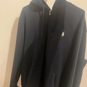 Mörkblå hoodie från Ralph Lauren - Säljer en stilren mörkblå hoodie från Ralph Lauren med dragkedja
