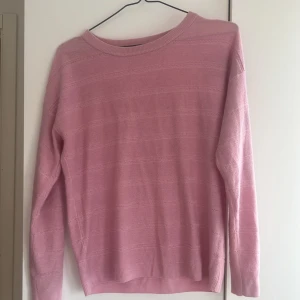 Rosa tröja från Jacqueline de Yong - Säljer en söt rosa tröja från Jacqueline de Yong i storlek medium. Tröjan har ett diskret randigt mönster och är långärmad med ribbade kanter. Perfekt för en mysig dag. (Tröjan är nopprig)