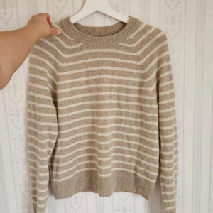 100% kashmir tröja - Säljer en mysig beige och vit randig tröja med långa ärmar i 100% kashmir. Så fin till en stilren outfit! Nypris 1800 kr från Samsøe. Mycket bra skick - knappt använd 🩷