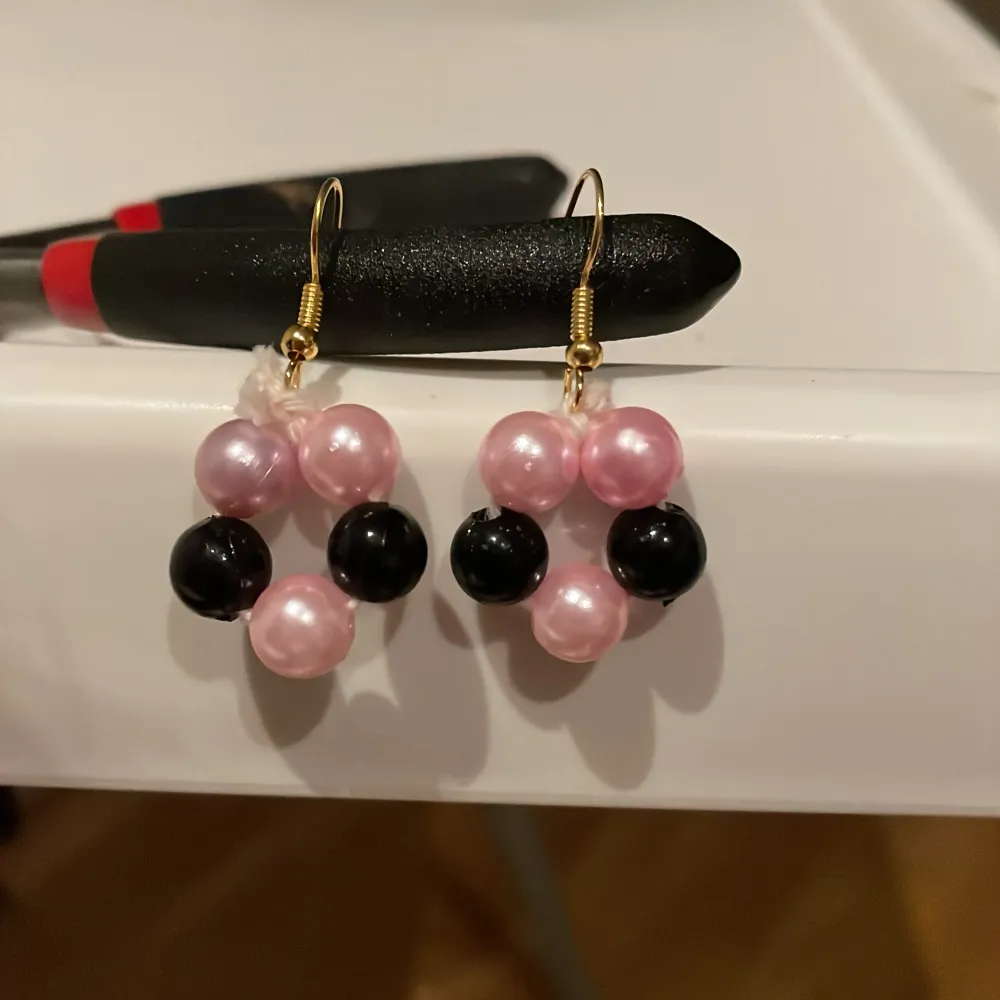 Säljer ett par  egentillverkade örhängen med pärlor i rosa och svart ⭐️. Asusteet.