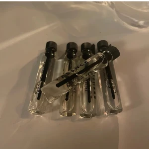 Parfymprov milky flower - Fem små parfymprover från Versace i genomskinliga glasflaskor med svarta skruvkorkar. Perfekt för att testa olika dofter eller ha med på resan. Varje flaska är märkt med Versace-logotypen.