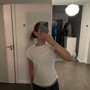 Vit t-shirt från Zara - Säljer en klassisk vit t-shirt från Zara i storlek 9-10. Perfekt basplagg med rund hals och korta ärmar. Tillverkad i mjukt material för en bekväm passform. Perfekt för vardagsbruk!