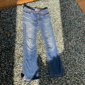 Blå bootcut jeans  - Snygga blå bootcut jeans från Calvin Klein med klassisk femficksdesign och knappgylf. 