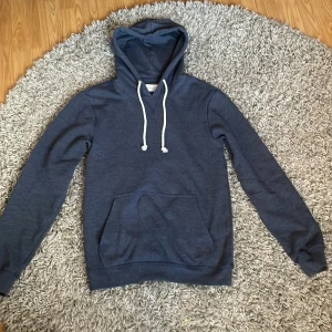 Mörkblå hoodie med ficka - Säljer en stilren mörkblå hoodie med huva. Hoodien är från pier one och den är inte använd så mycket. Hör av dig om frågor! 