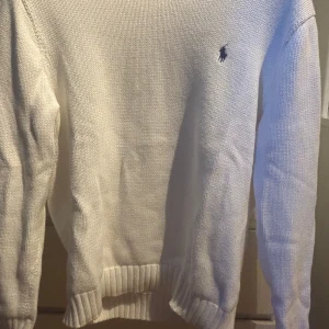 Vit stickad tröja från Ralph Lauren - Säljer en klassisk vit stickad tröja från Ralph Lauren den är perfekt för kyligare dagar. Ny pris går för 2200.