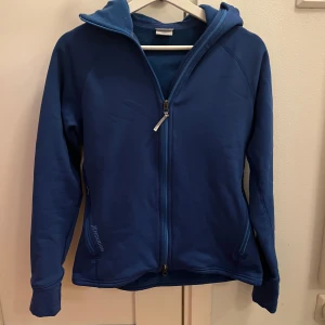 Blå fleectröja från Houdini - Säljer denna Houdini powerhoodie i storlek M dam. I princip ny och använd väldigt få gånger. Nypris 2400kr. Perfekt för utomhusaktiviteter men även mer stilrena tillfällen!