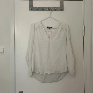 Vit blus från Lulus - Säljer en stilren vit blus från lulus med v-ringning och långa ärmar. Perfekt för både vardag och festliga tillfällen. Blusen har en luftig passform och är tillverkad i ett lätt material.