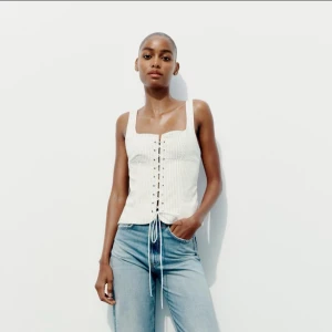 Vit korsettopp med snörning - Snygg vit, lite randig korsettopp med snörning framtill. Toppen har breda axelband och sååå snygg till jeans, kjol och shorts! Har knappt kommit till användning!💖