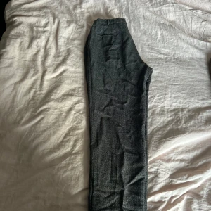 Grå kostymbyxor - Snygga grå kostymbyxor med en klassisk passform. Perfekta för en stilren look. Byxorna har en diskret textur och är tillverkade i ett bekvämt material.