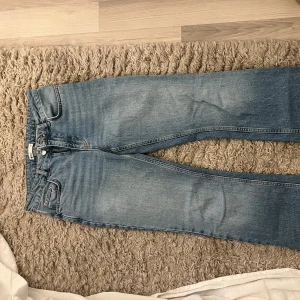 Blå jeans från Perfect Jeans - Snygga blå jeans från Gina  i storlek 38. De har en klassisk femficksdesign med knapp och dragkedja framtill. Utsvängda .