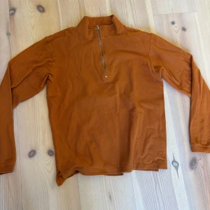 Orange tröja med dragkedja från Polar - Säljer en snygg orange tröja från Polar med halv dragkedja framtill. Tröjan har långa ärmar och en stilren design som passar perfekt för höst och vår. Perfekt för dig som gillar en avslappnad stil.