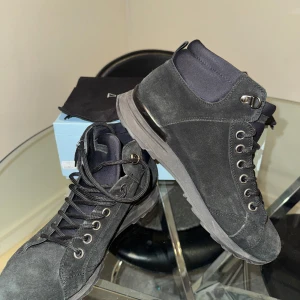 Svarta boots från Philippe Model - Säljer ett par svarta boots från Philippe Model med snörning och rund tå. Skorna är i mocka och har en platt sula. Perfekta för dig som vill ha en stilren och bekväm sko med snygga detaljer.