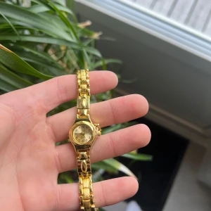 Guldklocka  - Helt oanvänd klocka med justerbart armband och nytt batteri. Den är gjort av 100% rostfrittstål. Armbandet justera du lätt hemma med hjälp av en nål. 