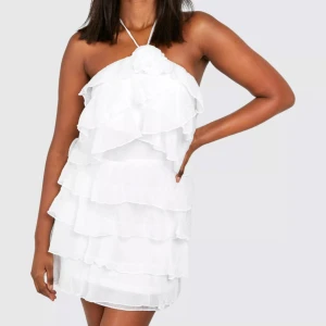 Vit volangklänning med lager på lager - Säljer en söt vit kortklänning med flera lager volanger. Klänningen är ärmlös och har en luftig känsla, perfekt för sommarens tillfällen. Materialet är lätt och ger en romantisk look. Den funkar också till studenten!!! 