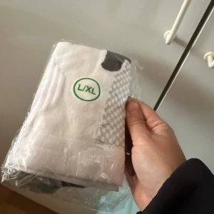 Vita och gråa strumpor L/XL - Säljer ett par nya vita strumpor med gråa detaljer. Strumporna är förpackade i plast och har en sportig look. Perfekta för dig som vill ha bekväma och stilrena strumpor till vardags.Kompressionsstrumpor för sport som padel, fotboll, innebandy och löpning. Stabiliserar för minskad smärta och snabbare återhämtning genom förbättrad blodcirkulation. Tillverkade av slitstarkt och bekvämt material.