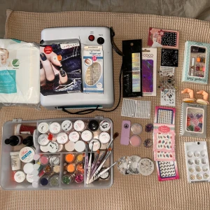 Stort nagelkit med dekorationer och penslar - Allt du behöver för att göra gelenaglar hemma! färgade glitter, UV-gel, penslar, nageldekorationer, stickers, lösnaglar och verktyg. Innehåller även nagelstenar, paletter och olika nagelstickers i färgglada och metallic nyanser  Kommer tyvärr inte kunna ta fler bilder då det tar upp alldeles för lång tid men finns i princip alla färger ni kan tänka er. Glitter, Chrome, smycken, uv-lampa mm..  Det är i befintligt skick: vissa grejer är oöppnade medans vissa är halvfulla.   Nypris är ca 2000kr