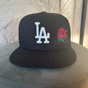 Svart LA Dodgers keps med rosbrodyr - New era fitted använd fåtal gånger. Mycket bra skick. Storlek 7 1/8 (56,8 cm). Pris kan diskuteras! 