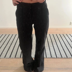 Svarta kostymbyxor - Snygga svarta kostymbyxor med en bootcut stil. Byxorna har hög midja och klassisk dragkedja framtill. Skit snygga och passar så bra till allt, plus man ser alltid lyxig ut när man har kostymbyxor!!
