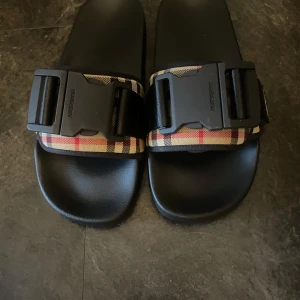 Burberry tofflor  med spännare - Riktigt fina tofflor med spännare till sommaren helt nya bara testade
