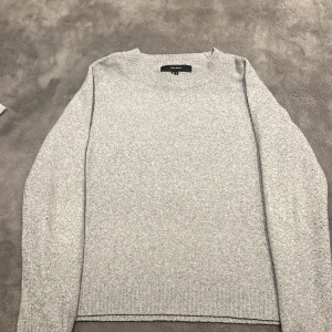 Grå stickad tröja  - Säljer en stilren grå stickad tröja från H&M. Tröjan har en klassisk rund hals och långa ärmar. Perfekt för kyligare dagar. Passar bra till både jeans och kjol.