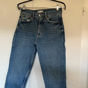 Blå jeans  - Säljer ett par klassiska blå jeans. De har en rak passform och är högmidjade med dragkedja och knapp framtill. Från ginatricot 